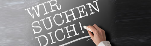 Eine Person schreibt auf einer Tafel die Worte „wir schuchen dich“.