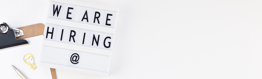 Ein Schild mit der Aufschrift „Wir stellen ein“ auf weißem Hintergrund.