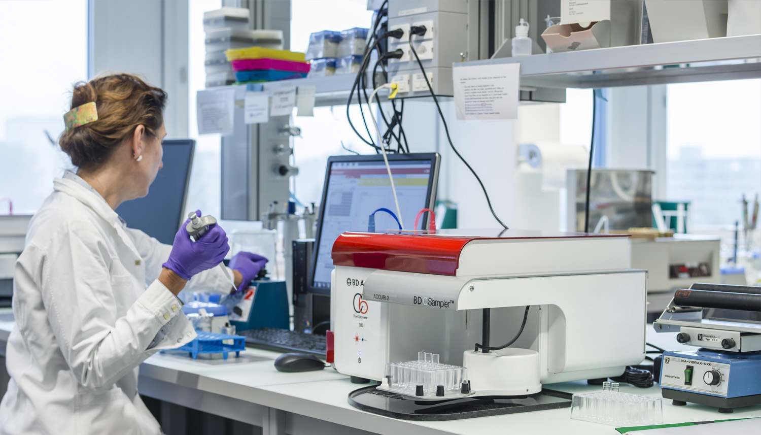 Eine Frau arbeitet in einem Labor mit einem Mikroskop.