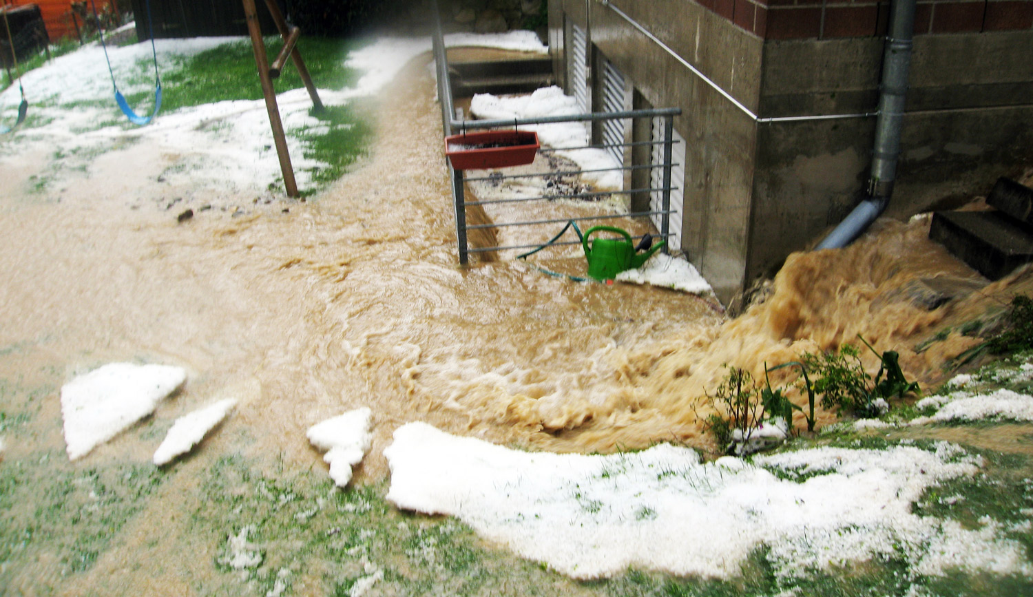 Eine überflutete Straße mit einem Gebäude im Hintergrund.