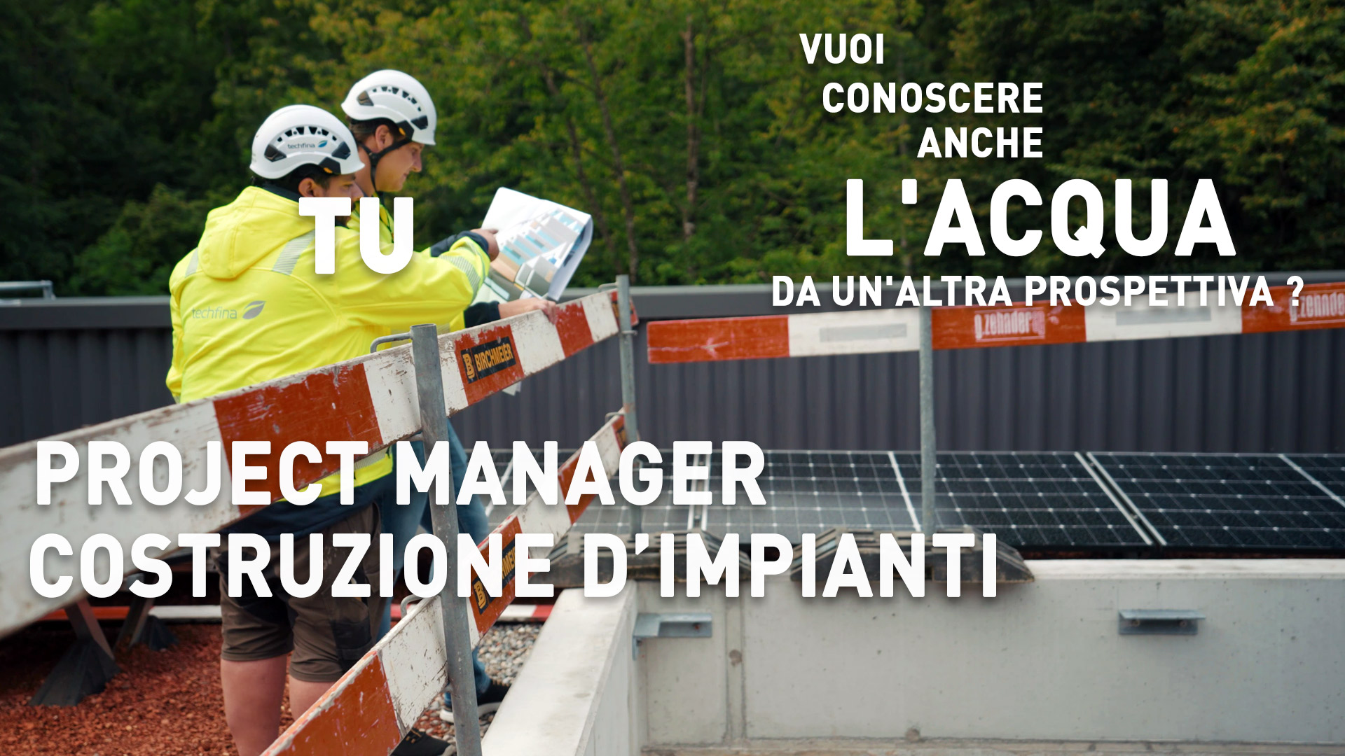 Zwei Bauarbeiter in gelben Jacken und Helmen pr&uuml;fen Pl&auml;ne auf der Baustelle f&uuml;r die Installation von Solarmodulen. Text&uuml;berlagerung auf Italienisch.